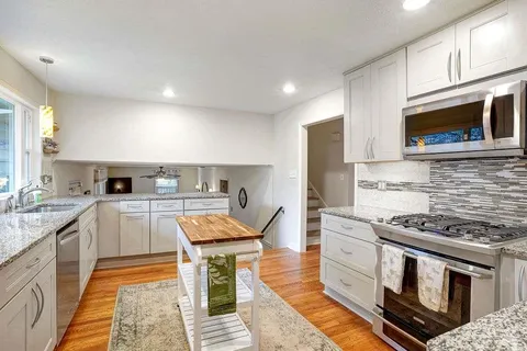a kitchen with stainless steel appliances granite countertop a stove and a sink