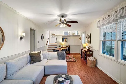 a living room with furniture a chandelier and a large window