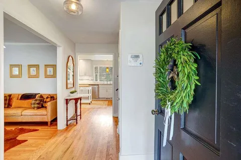 an entryway with a flower pot and a bookshelf