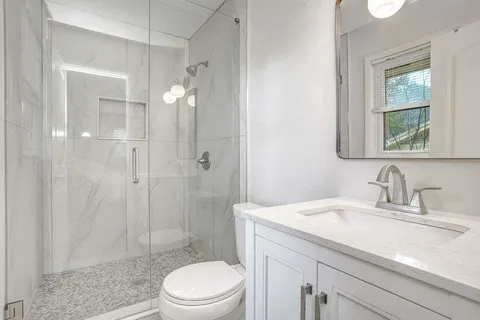 a bathroom with a sink a toilet and shower