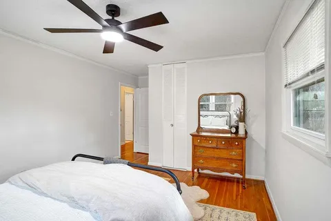 a bedroom with a bed and wooden floor