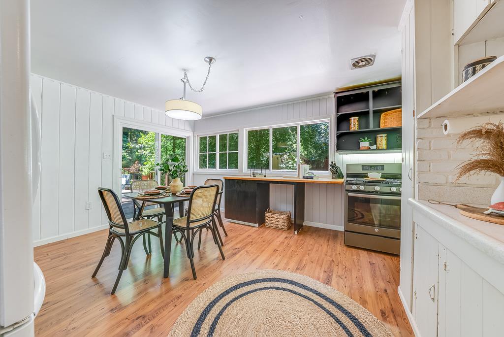 168 Riverside Drive Boulder Creek, CA 95006 - Photo 11 of 52 a kitchen with stainless steel appliances granite countertop a stove a sink a refrigerator dining table and chairs with wooden floor