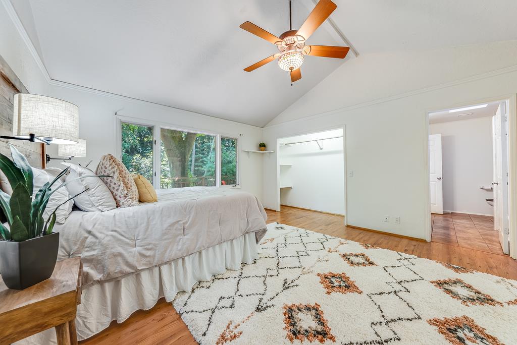168 Riverside Drive Boulder Creek, CA 95006 - Photo 22 of 52 a bed room with a large bed and a chandelier