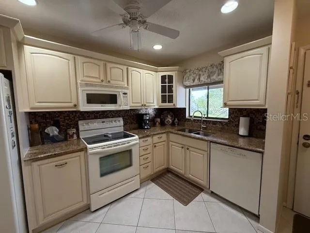 a kitchen with stainless steel appliances granite countertop white cabinets granite counter tops and a window