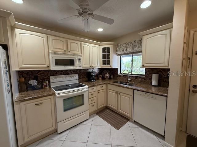 1648 Stickney Point Road, Unit 48202 Sarasota, FL 34231 - Photo 2 of 18 a kitchen with stainless steel appliances granite countertop white cabinets granite counter tops and a window
