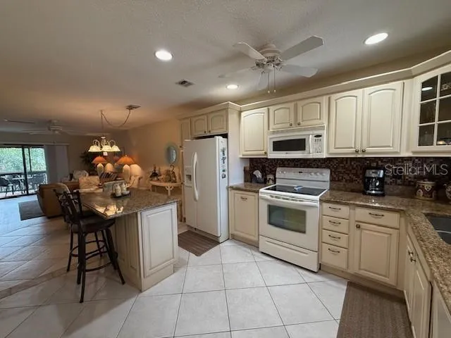 a kitchen with stainless steel appliances kitchen island granite countertop a sink cabinets and wooden floor