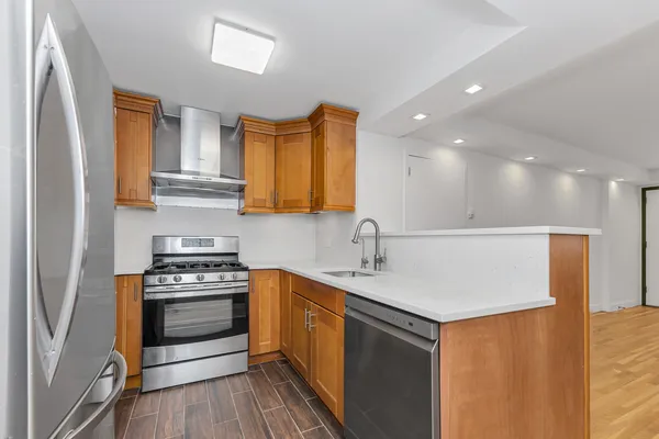 a kitchen with stainless steel appliances granite countertop a sink a stove and a refrigerator
