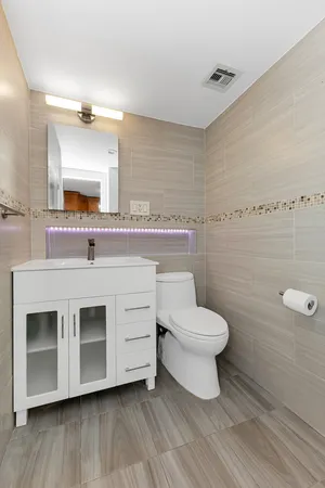 a bathroom with a toilet sink and mirror
