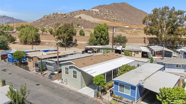 a aerial view of a white house with a yard and potted plants