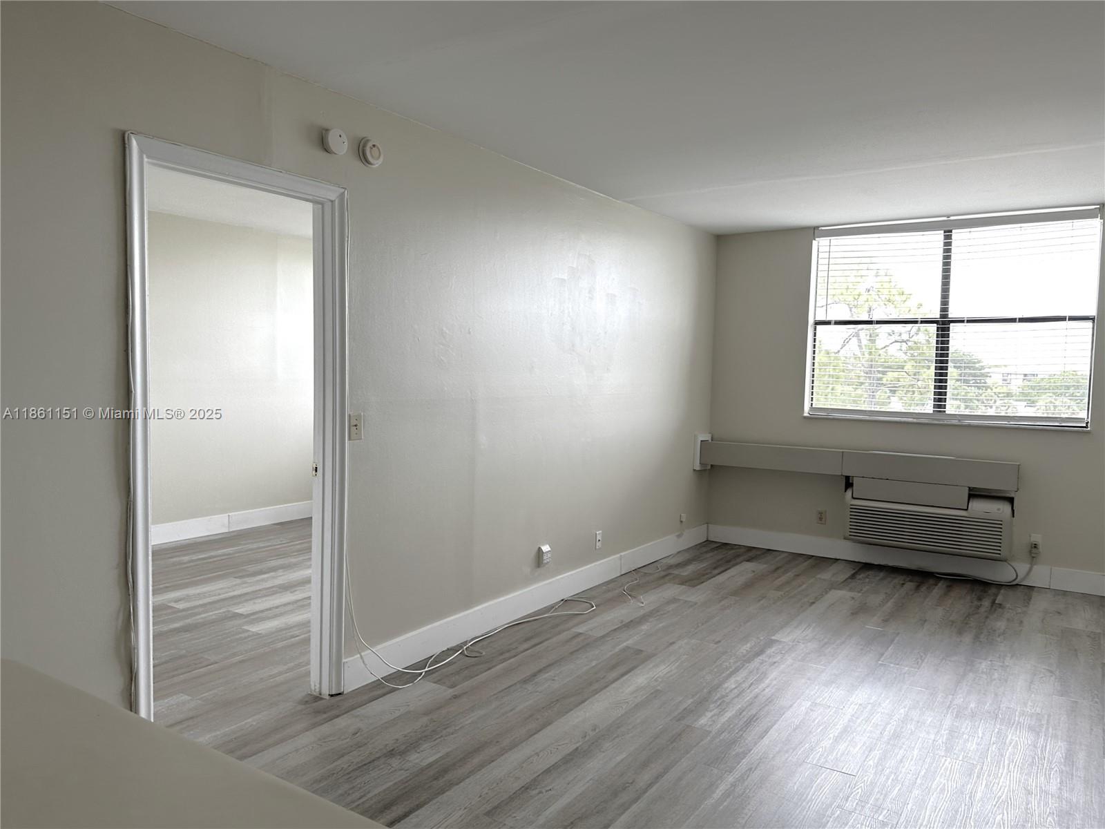 2501 Riverside Drive, Unit 506A Coral Springs, FL 33065 - Photo 9 of 15 an empty room with wooden floor and windows