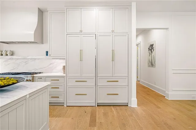 a kitchen with a refrigerator and white cabinets