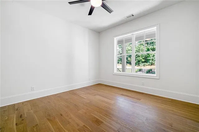 an empty room with a window and a ceiling fan