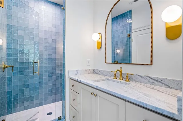 a bathroom with a granite countertop sink and a mirror
