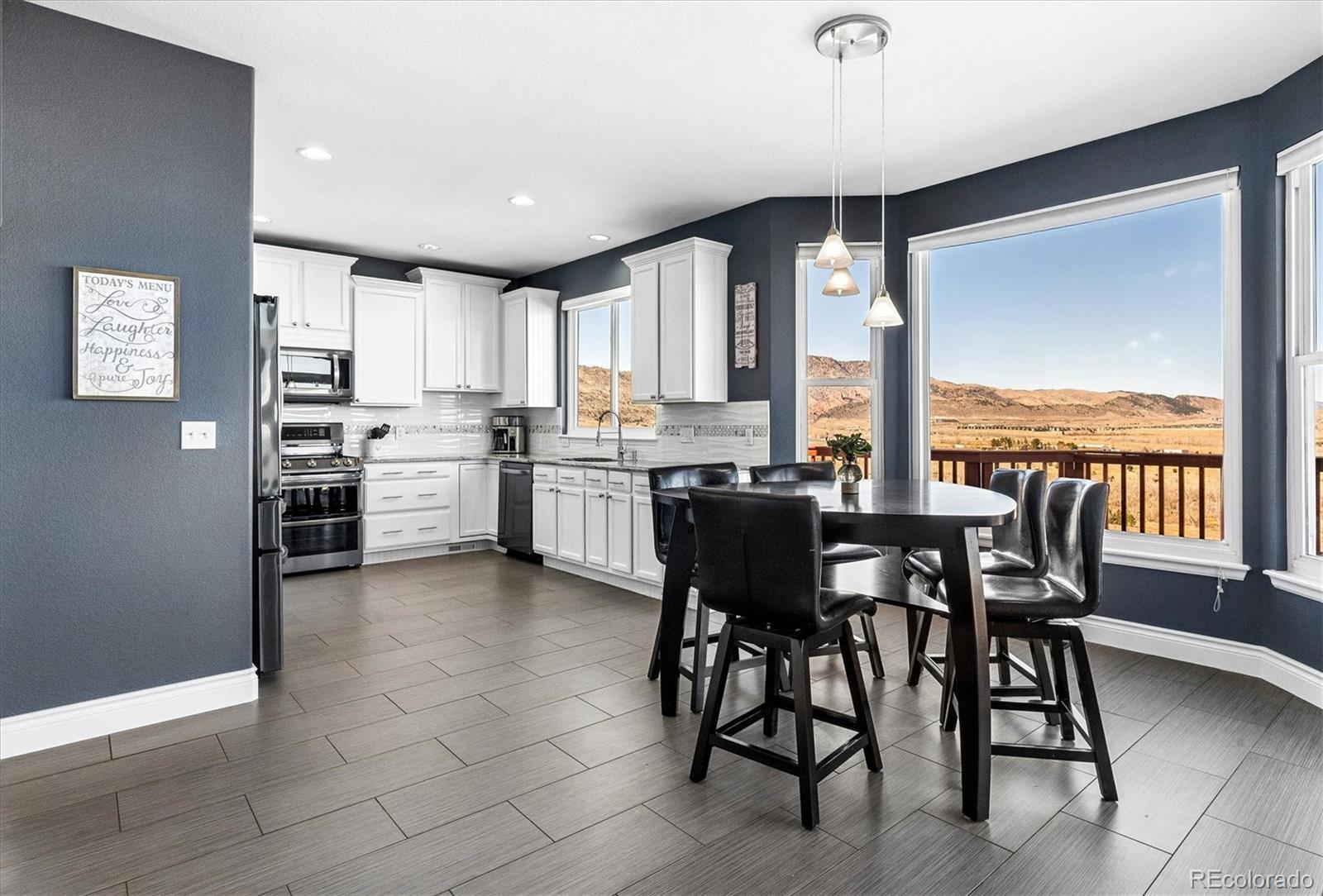 4143 South Deframe Court Morrison, CO 80465 - Photo 19 of 48 a kitchen with a table chairs sink and cabinets