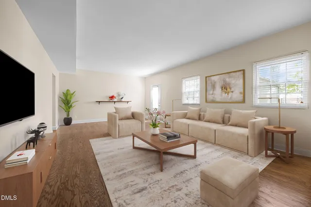 a living room with furniture a flat screen tv and a large window