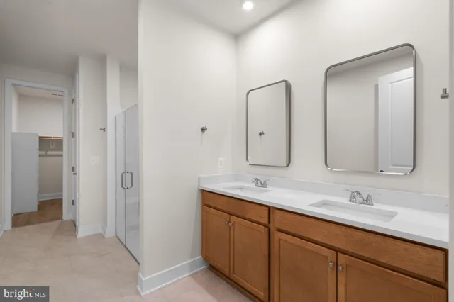 a bathroom with double vanity sinks and a mirror