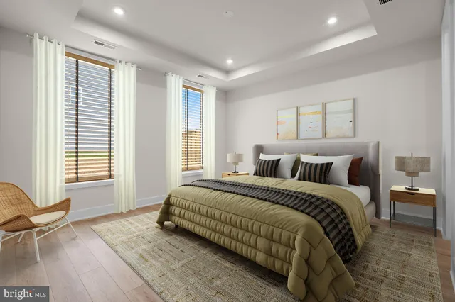 a spacious bedroom with a bed and wooden floor