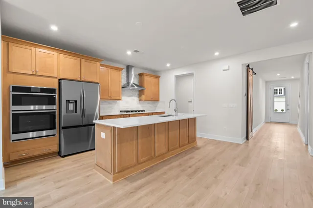 a kitchen with stainless steel appliances a refrigerator and a stove top oven