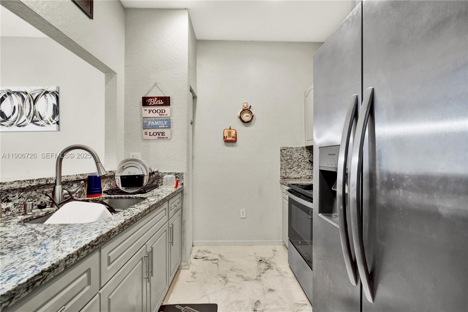 10973 Southwest 238th Street Homestead, FL 33032 - Photo 5 of 25 a kitchen with stainless steel appliances granite countertop a refrigerator a stove and a sink