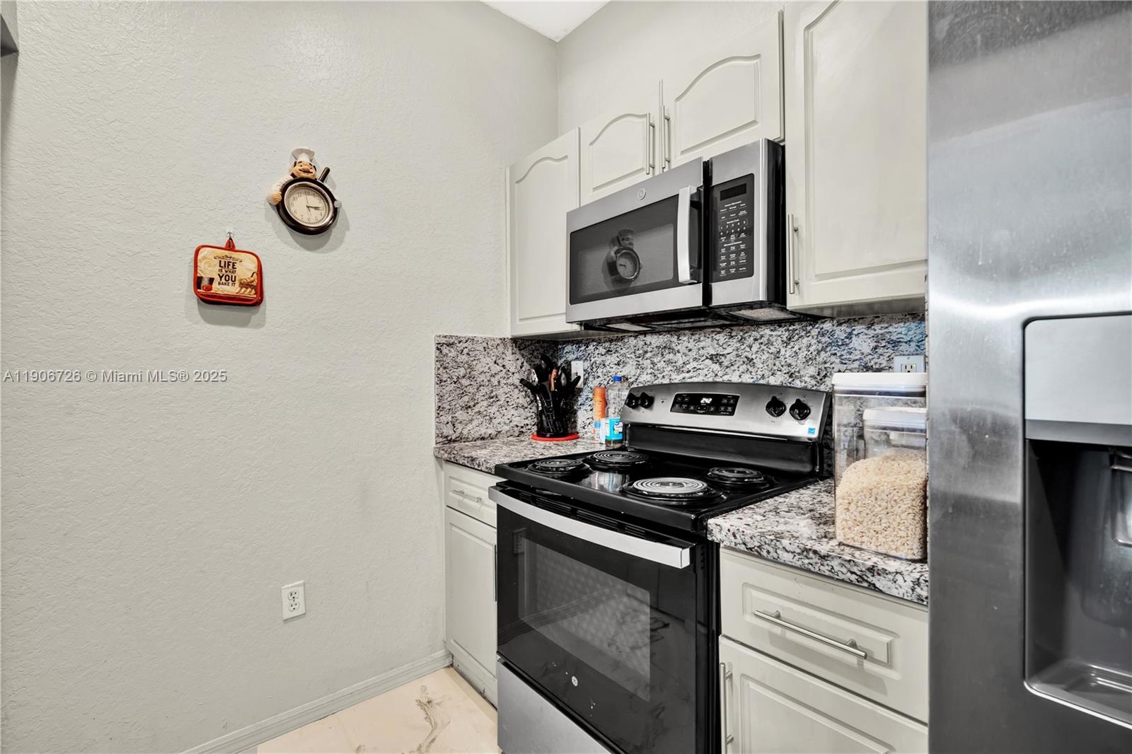 10973 Southwest 238th Street Homestead, FL 33032 - Photo 6 of 25 a kitchen with white cabinets and a stove top oven