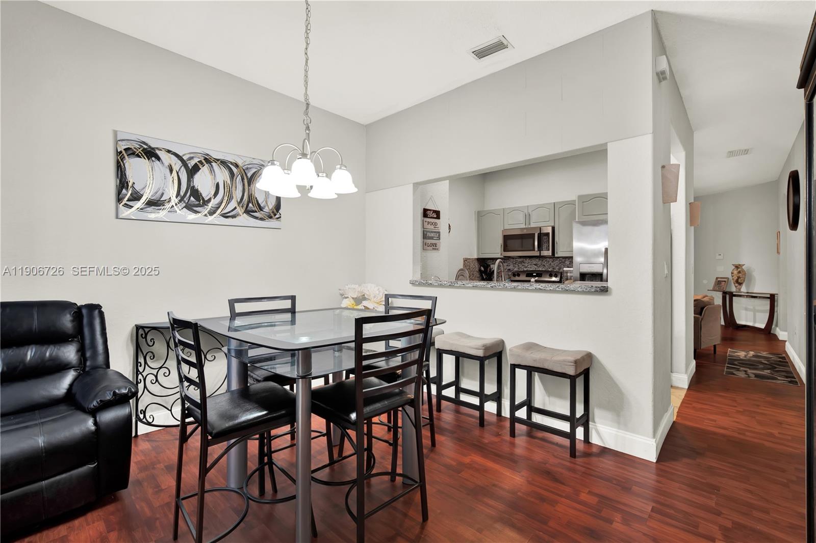 10973 Southwest 238th Street Homestead, FL 33032 - Photo 8 of 25 a view of a dining room with furniture wooden floor and a chandelier