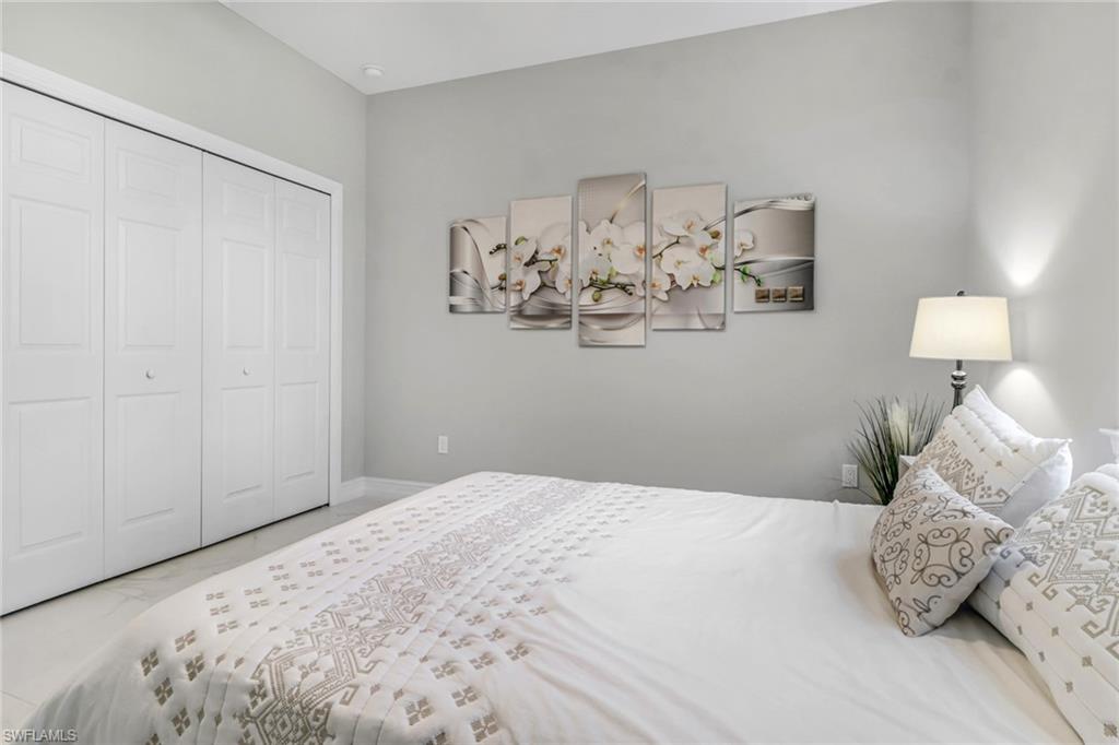 4143 2nd Avenue Northeast Naples, FL 34120 - Photo 11 of 15 a bedroom with a bed and a chandelier
