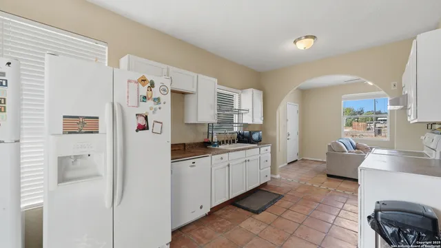 a view of a kitchen with fridge and workspace