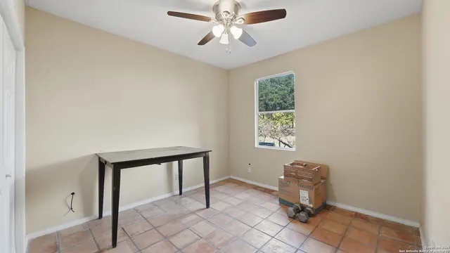 a view of an empty room and chandelier fan