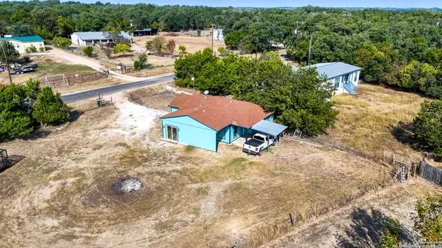 an aerial view of a house with a yard and lake view