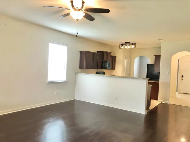 an empty room with a window and a ceiling fan