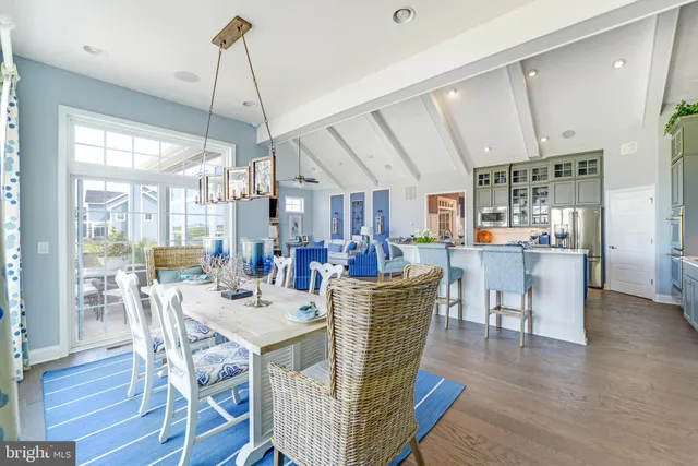 a view of a dining room and livingroom with furniture wooden floor a chandelier