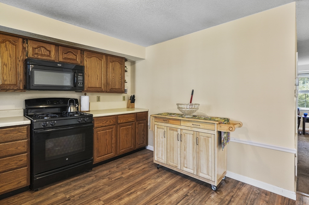 34 Century Way, Unit 34 Gardner, MA 01440 - Photo 11 of 30 a kitchen with stainless steel appliances granite countertop a stove microwave and sink