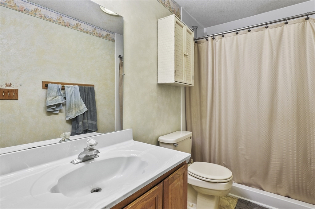 34 Century Way, Unit 34 Gardner, MA 01440 - Photo 19 of 30 a bathroom with a sink a toilet and shower curtain