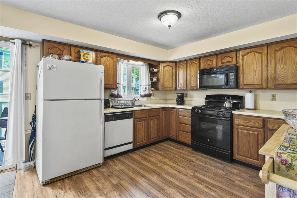 34 Century Way, Unit 34 Gardner, MA 01440 - Photo 10 of 30 a kitchen with a refrigerator a stove top oven a sink and a window