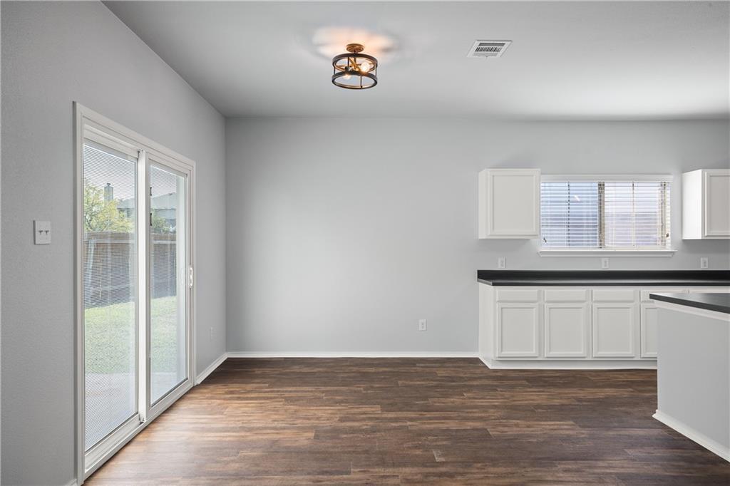19909 Sap Cove Round Rock, TX 78664 - Photo 11 of 22 Spacious interior featuring wood-finish flooring, light grey walls, and a contemporary ceiling light fixture