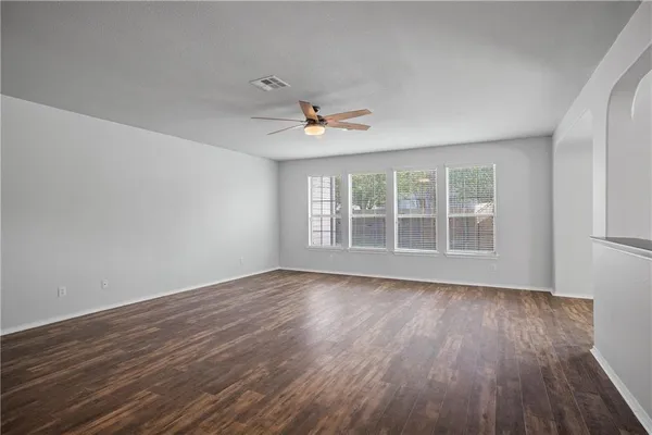 a view of wooden floor and a chandelier fan in a room