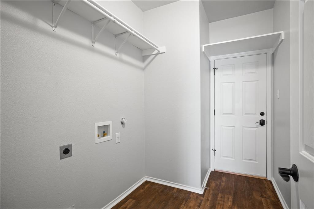 19909 Sap Cove Round Rock, TX 78664 - Photo 17 of 22 Utility space featuring wood-finish flooring, white walls, and a white six-panel door with matte black hardware