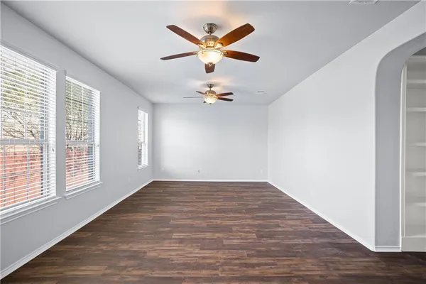 an empty room with fan and windows