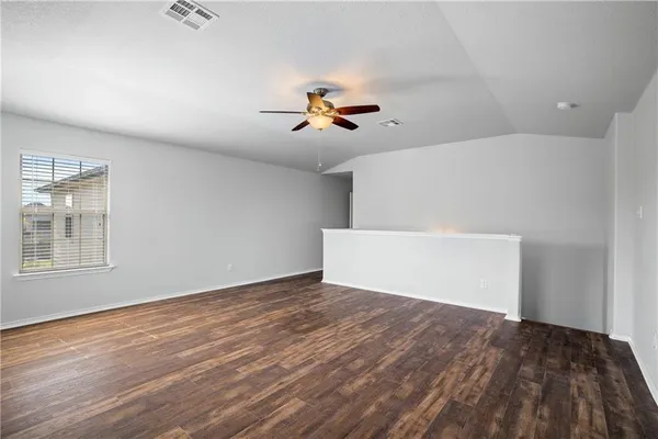a view of a room with wooden floor and a ceiling fan