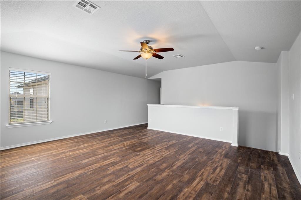 19909 Sap Cove Round Rock, TX 78664 - Photo 19 of 22 Spacious room featuring wood-finish flooring, a contemporary ceiling fan, and a neutral color palette