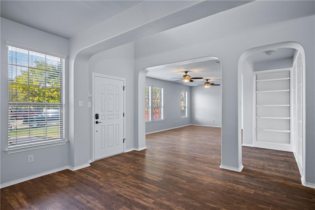 19909 Sap Cove Round Rock, TX 78664 - Photo 6 of 22 Entryway featuring wood-finish flooring, a paneled front door, and a built-in shelving unit