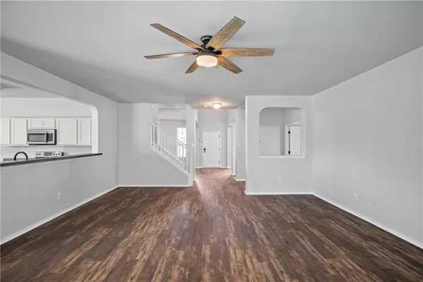 a view of a livingroom with wooden floor and a ceiling fan