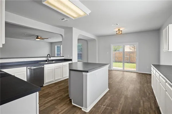 a kitchen with granite countertop a sink and a stove top oven