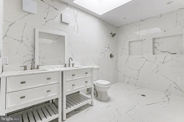a bathroom with a double vanity sink mirror and toilet