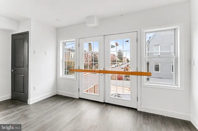 a view of a hallway with wooden floors and cabinet