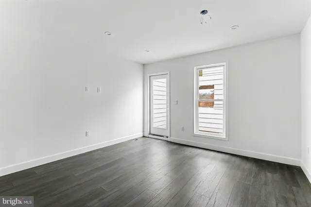an empty room with wooden floor and window