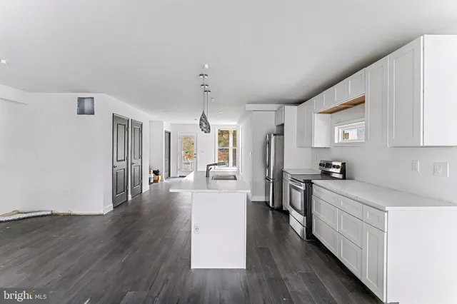 a kitchen with a sink a counter top space and stainless steel appliances