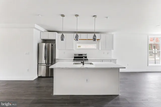 a kitchen with kitchen island a sink a stove a refrigerator and a window