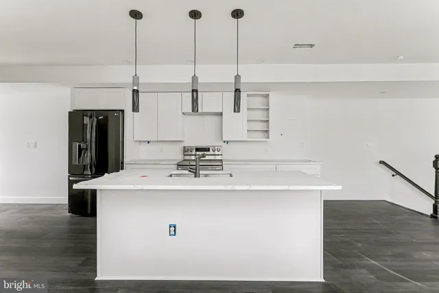 a kitchen with stainless steel appliances kitchen island a sink a stove and a refrigerator