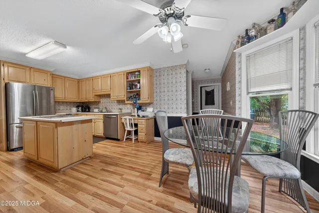 a kitchen with a dining table chairs and refrigerator